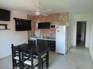 Una cocina con una mesa y un refrigerador blanco. en La Villa Inn, en Villa Carlos Paz