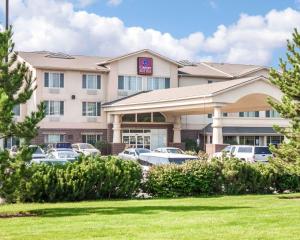 Un hotel con coches aparcados en un estacionamiento. en Comfort Suites Airport, en Boise