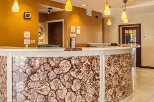 a lobby with a counter with a stone wall at Comfort Suites Bloomington I-55 and I-74 in Bloomington