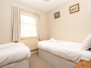 1 dormitorio con 2 camas y ventana en Anvil House, en Weymouth