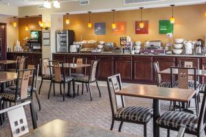 a restaurant with tables and chairs and a counter at Comfort Suites Bloomington I-55 and I-74 in Bloomington