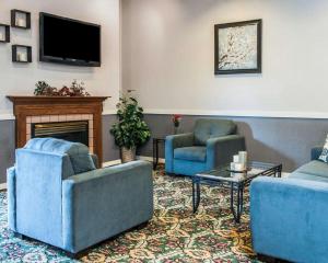 sala de estar con 2 sillas azules y chimenea en Quality Inn, en Rochester