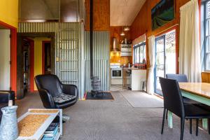 sala de estar con mesa y sillas y cocina en Corru Gate en Mapua