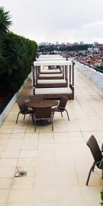 a patio with chairs and tables on a roof at Pajuçara Front Beach in Maceió