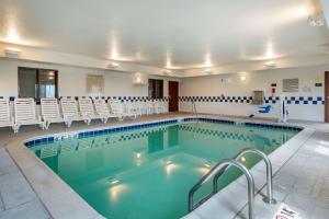 - une grande piscine avec des chaises dans un bâtiment dans l'établissement Comfort Inn & Suites Muncie, à Muncie