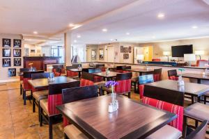 un restaurante con mesas de madera y sillas con flores. en Comfort Inn Washington DC Joint Andrews AFB, en Clinton