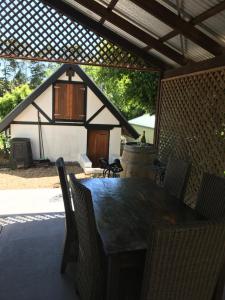 a table and chairs in a patio with a house at Ted and Stellas on Tamborine in Mount Tamborine