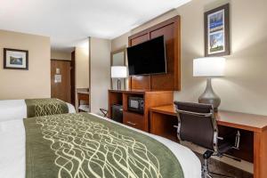 a hotel room with a bed and a desk with a computer at Comfort Inn & Suites Dimondale - Lansing in Dimondale