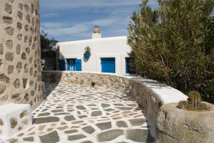 a stone walkway in front of a white building at Windmill Studios in Livadi