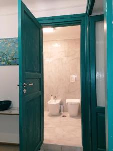 zielone drzwi prowadzące do łazienki z toaletą w obiekcie CasaCasetta Suite Appartamento Indipendente w mieście Tarent