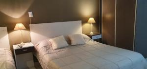 sypialnia z białym łóżkiem z 2 lampami w obiekcie Del Pilar II w mieście La Rioja