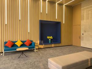 sala de estar con sofá azul y TV en Holiday Inn Express Changsha South Railway Station, an IHG Hotel, en Changsha