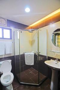 a bathroom with a shower and a toilet and a sink at Caliraya Resort Club in Lumban
