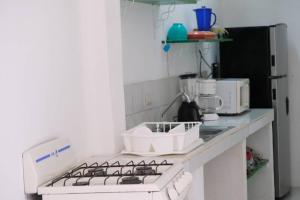 a kitchen with a stove top oven next to a refrigerator at Depa Versalles Puerto Vallarta in Puerto Vallarta