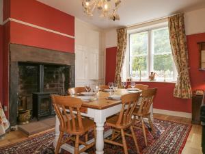 a dining room with a table and chairs and a fireplace at Dale House in Cockermouth