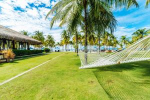 a hammock in a resort with palm trees and the ocean at Bohol Beach Club in Panglao Island