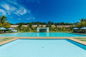 a large swimming pool with a blue sky in the background at Bohol Beach Club in Panglao Island