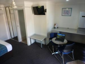 a room with a bed, desk and a television at Aspley Carsel Motor Inn in Brisbane