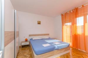a bedroom with a blue bed and a window at Rooms Mira II in Vodice +18 photos