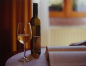 una botella de vino y una copa en una mesa en Villa Hochdörffer Gästehaus, en Landau in der Pfalz