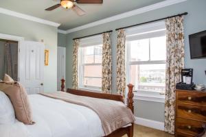 ein Schlafzimmer mit einem Bett und zwei Fenstern in der Unterkunft Almondy Inn Bed & Breakfast in Newport