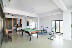 a room with a pool table and two exercise bikes at Super OYO 117 King One Suvarnabhumi in Bangkok