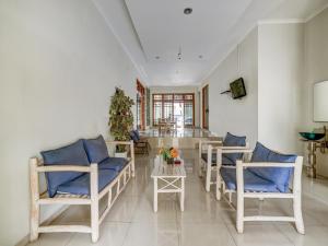 sala de estar con sillas azules y mesa en Collection O 3945 Bale Tardian Syariah, en Yogyakarta