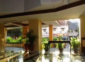 un vestíbulo con macetas en un edificio en Hotel Mutiara Baru, en Batu
