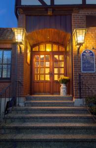 a front door of a brick building with stairs at Hotel Landgasthof Puck in Böddenstedt