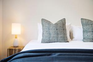 een slaapkamer met een bed met blauwe lakens en kussens bij The Laneway in Mudgee