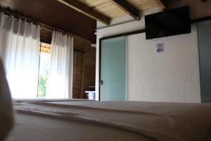 a bedroom with a bed and a sliding glass door at Garten Chalés in Pomerode