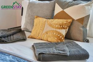 a bed with pillows and blankets on it at "Clarence Court Newcastle" by Greenstay Serviced Accommodation - Stunning 1 Bed Apt In City Centre With Parking & Balcony-Sleeps 4 - Perfect For Contractors, Business Travellers, Couples & Families - Fast Wi-Fi - Long Stays Welcome in Newcastle upon Tyne