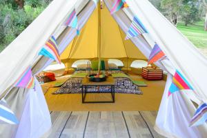 a tent with a table in front of it at Iluka Retreat Glamping Village in Red Hill South