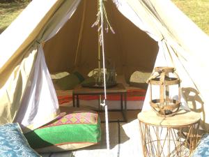 a tent with a table and a lamp in it at Iluka Retreat Glamping Village in Red Hill South
