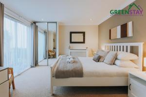 een slaapkamer met een bed en een groot raam bij "The Penthouse Newquay" by Greenstay Serviced Accommodation - Stunning 3 Bed Apt With Parking & Sun Terrace - The Perfect Choice For Families, Small Groups & Business Travellers - Newly Refurbished - Close To Beaches, Shops & Restaurants in Newquay