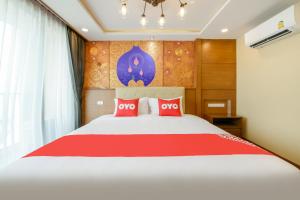 une chambre avec un grand lit avec des oreillers rouges dans l'établissement OYO 458 Nakorn Siam Boutique, à Pattaya