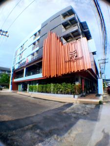 een groot gebouw met een oranje structuur ervoor bij Modern Budget Hotel in Hat Yai
