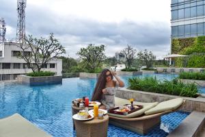 a woman standing next to a pool at a hotel at Shangri-La Bengaluru in Bangalore