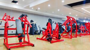 a gym with red tread machines in a room at Fulitai International Hotel in Yantai