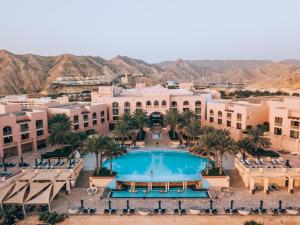 ein Luftblick auf ein Resort mit einem Pool und Palmen in der Unterkunft Shangri-La Al Husn, Muscat - Adults Only Resort in Muscat
