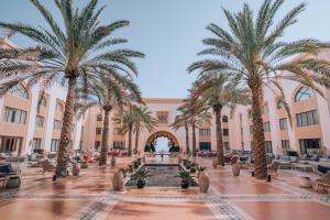 un patio con palmeras y una fuente en Shangri-La Al Husn, Muscat - Adults Only Resort, en Mascate