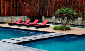 a row of red lounge chairs next to a swimming pool at Crowne Plaza Pune City Centre, an IHG Hotel in Pune