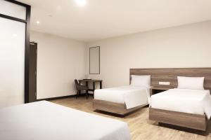 a hotel room with two beds and a desk at ACES Hotel Kuala Lumpur in Kuala Lumpur