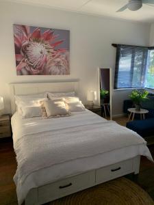 a bedroom with a white bed with a painting on the wall at Moana Beach Sunset Holiday Accommodation B in Moana