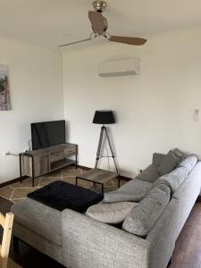 a living room with a couch and a ceiling fan at Moana Beach Sunset Holiday Accommodation B in Moana