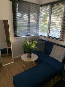 a living room with a blue couch and a table at Moana Beach Sunset Holiday Accommodation B in Moana