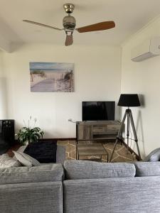 a living room with a couch and a flat screen tv at Moana Beach Sunset Holiday Accommodation B in Moana