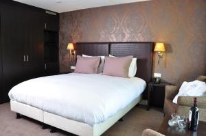 una camera da letto con un grande letto con cuscini rosa di Fletcher Hotel Jan van Scorel a Schoorl