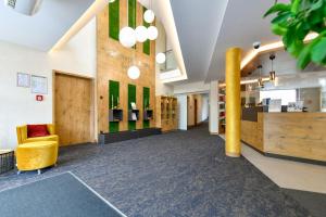 una hall di una biblioteca con una sedia gialla di Best Western Plus Parkhotel & Spa Cottbus a Cottbus