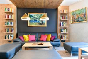 a living room with a blue couch with colorful pillows at Best Western Plus Parkhotel & Spa Cottbus in Cottbus